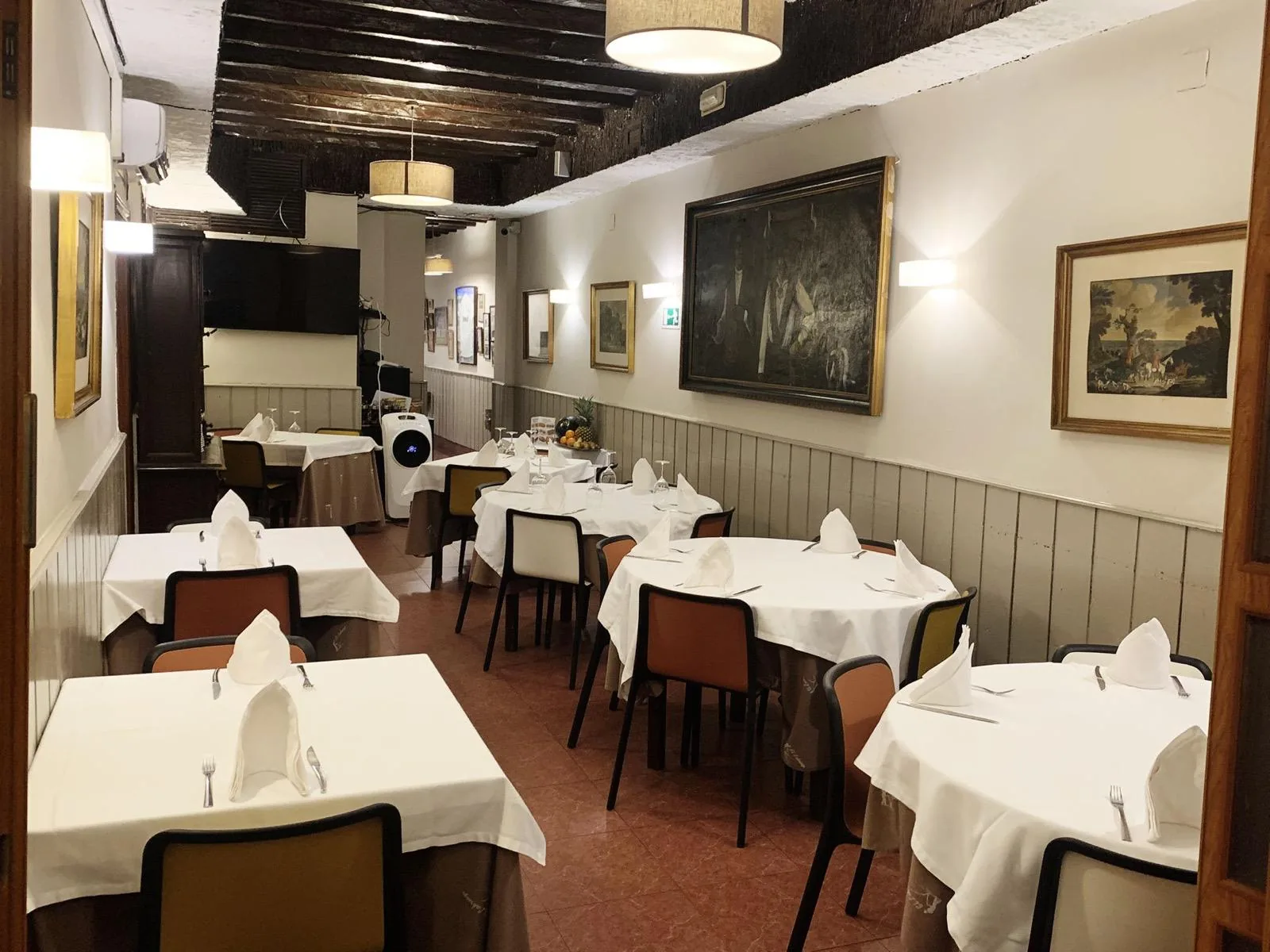 Comedor de El Labriego con vigas de madera y mesas vestidas de blanco